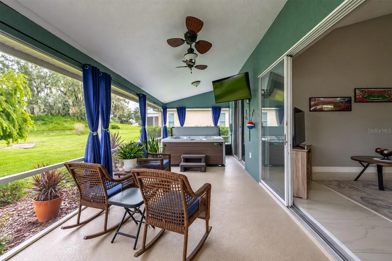 Spacious screened lanai just off the great room, featuring a relaxing seating area, outdoor TV and hot tub.