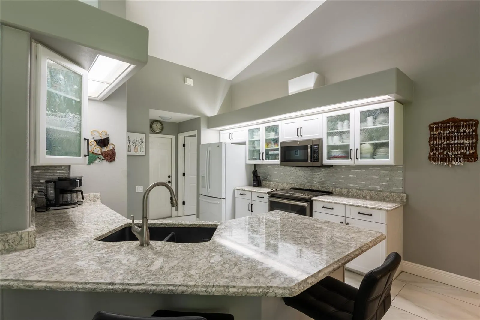 Kitchen with upgraded granite counters and tile backsplash.