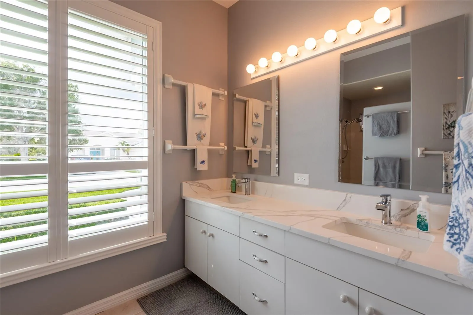 Updated bathroom with dual sinks and granite counters.