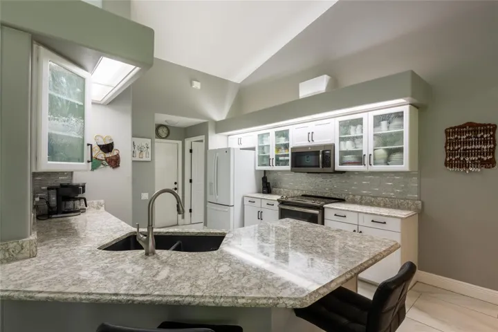 Kitchen with upgraded granite counters and tile backsplash.