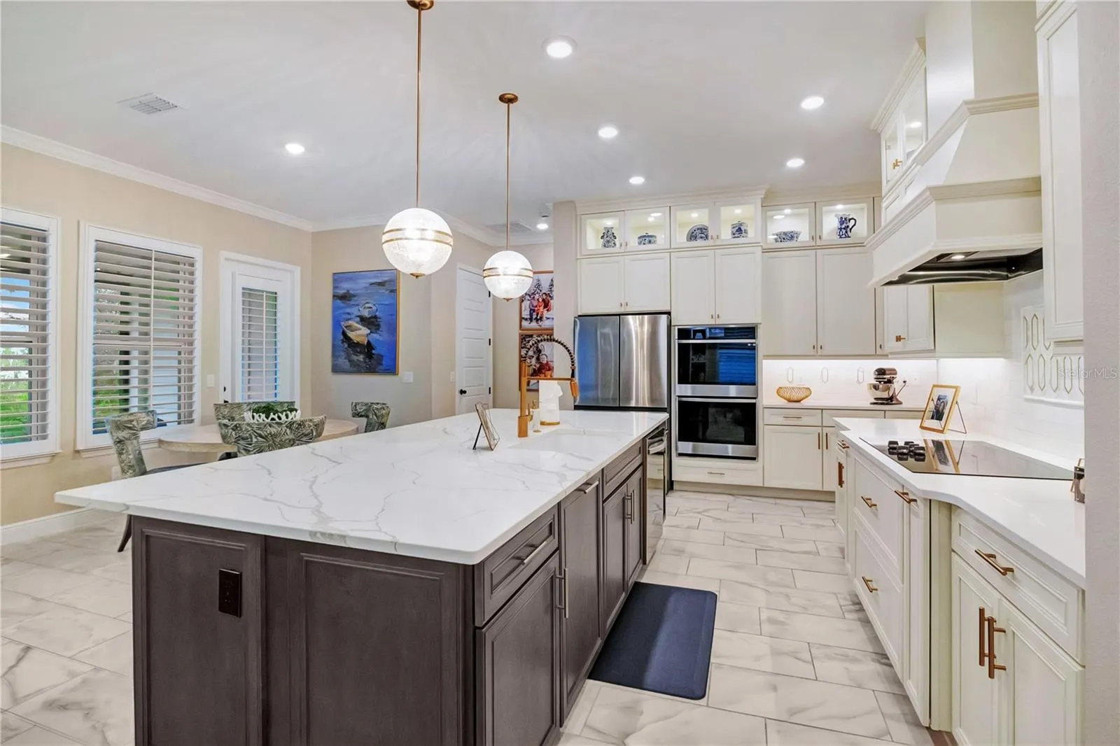 Beautifully appointed kitchen featuring a decorative backsplash, statement range hood and abundant cabinet storage.