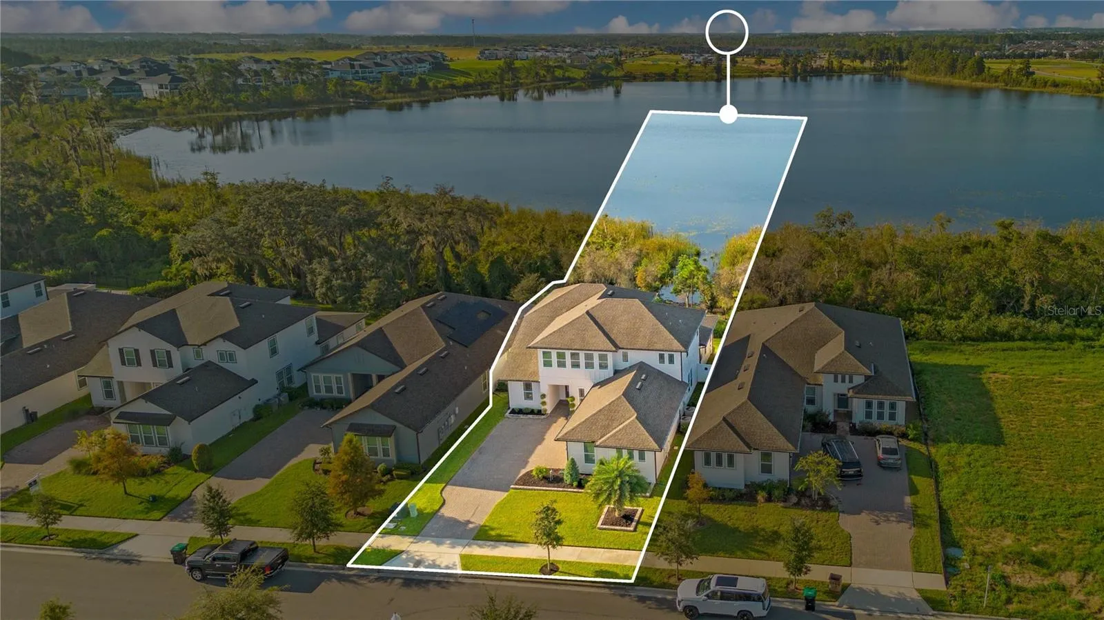 Aerial view highlights the home’s setting beside the lake. Outline is approximate and for illustration only.