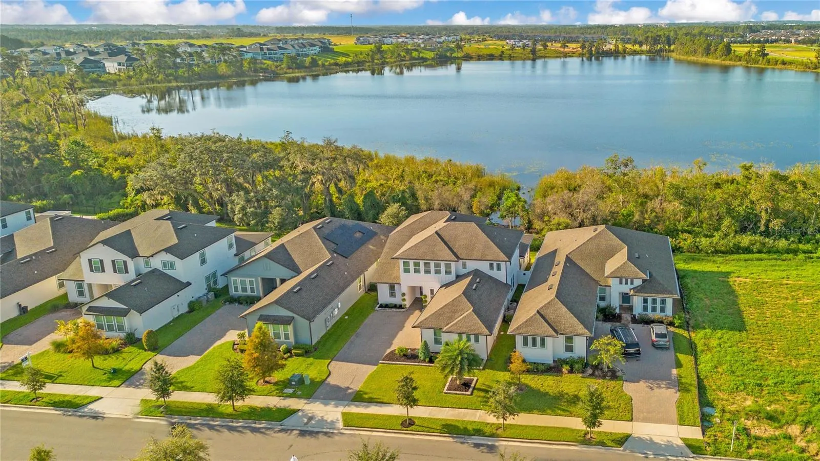 Aerial view showcasing the home’s scenic setting with the lake behind it.