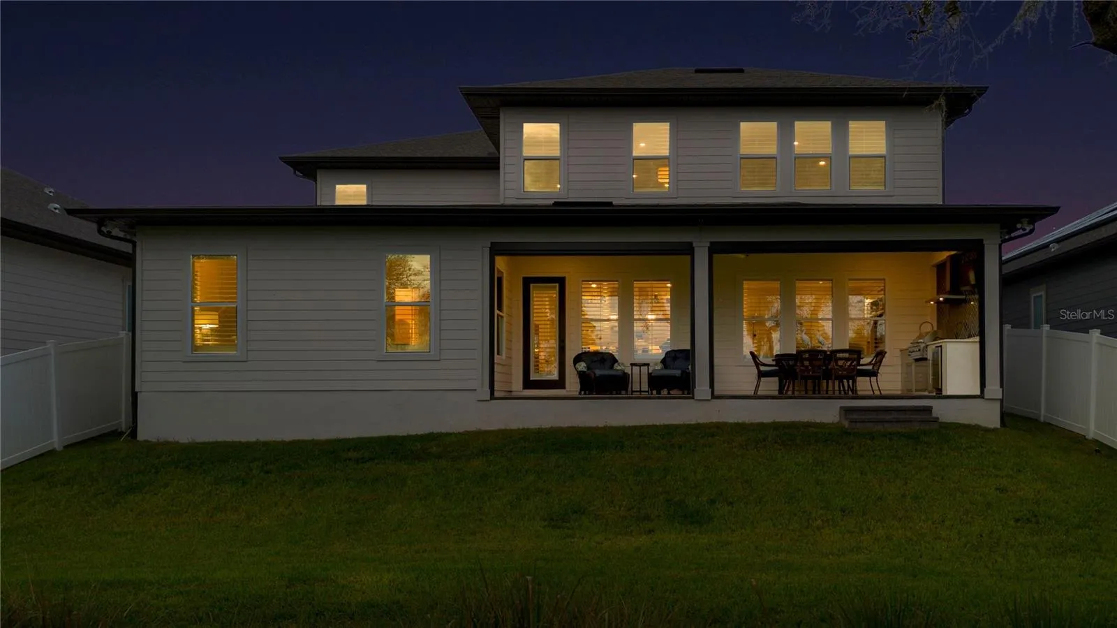 Rear twilight view featuring the covered lanai and inviting outdoor living areas.