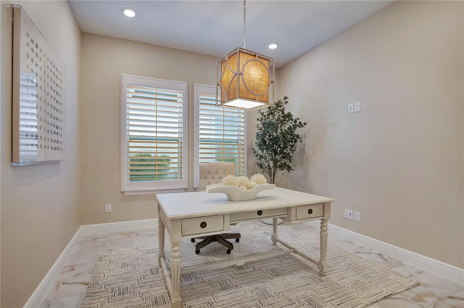 Dedicated office featuring plantation shutters, recessed lighting and a decorative pendant fixture.