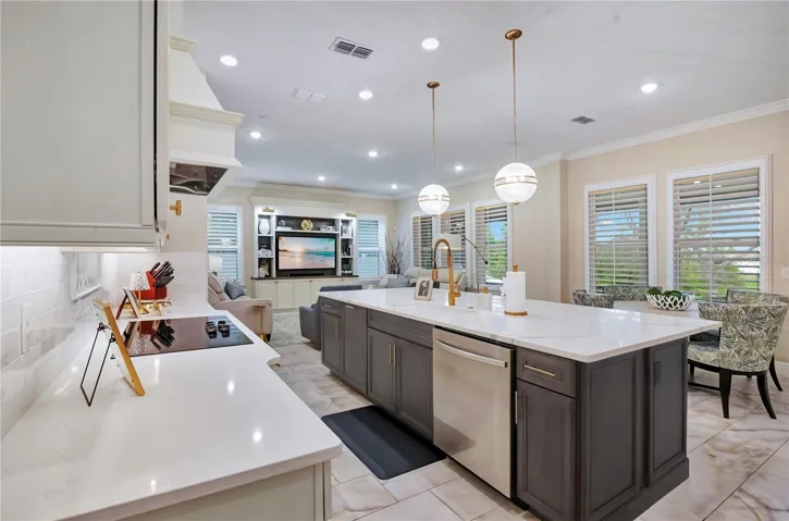 Expansive kitchen island features an undermount sink, built-in dishwasher and generous preparation space.