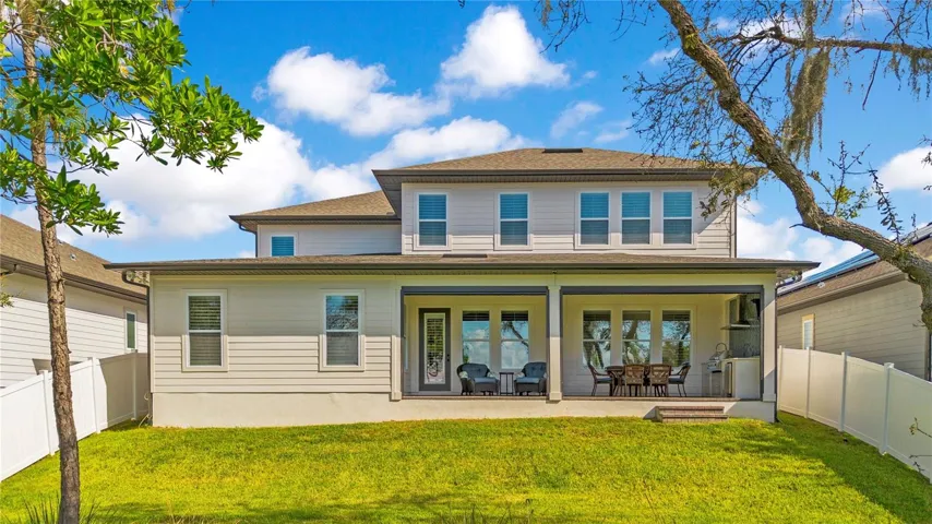 Spacious covered lanai with ceiling fans and roll-up screens extends the home’s outdoor living space.