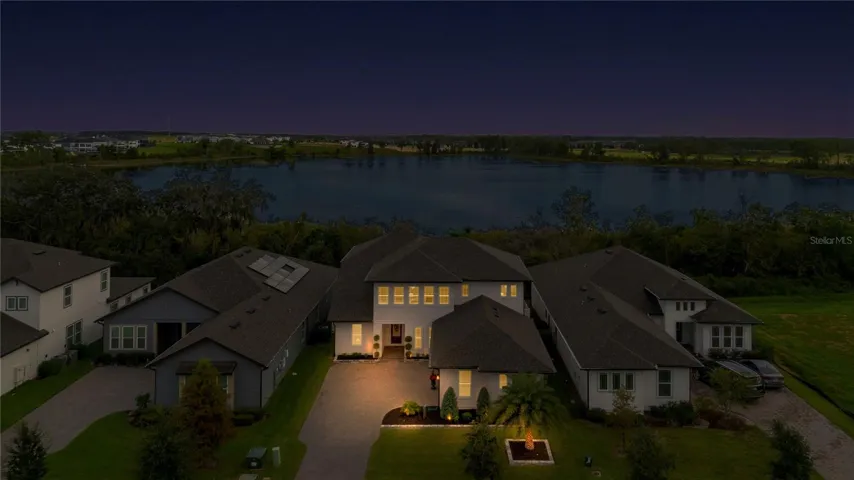 Elevated twilight view featuring the home and lake backdrop.