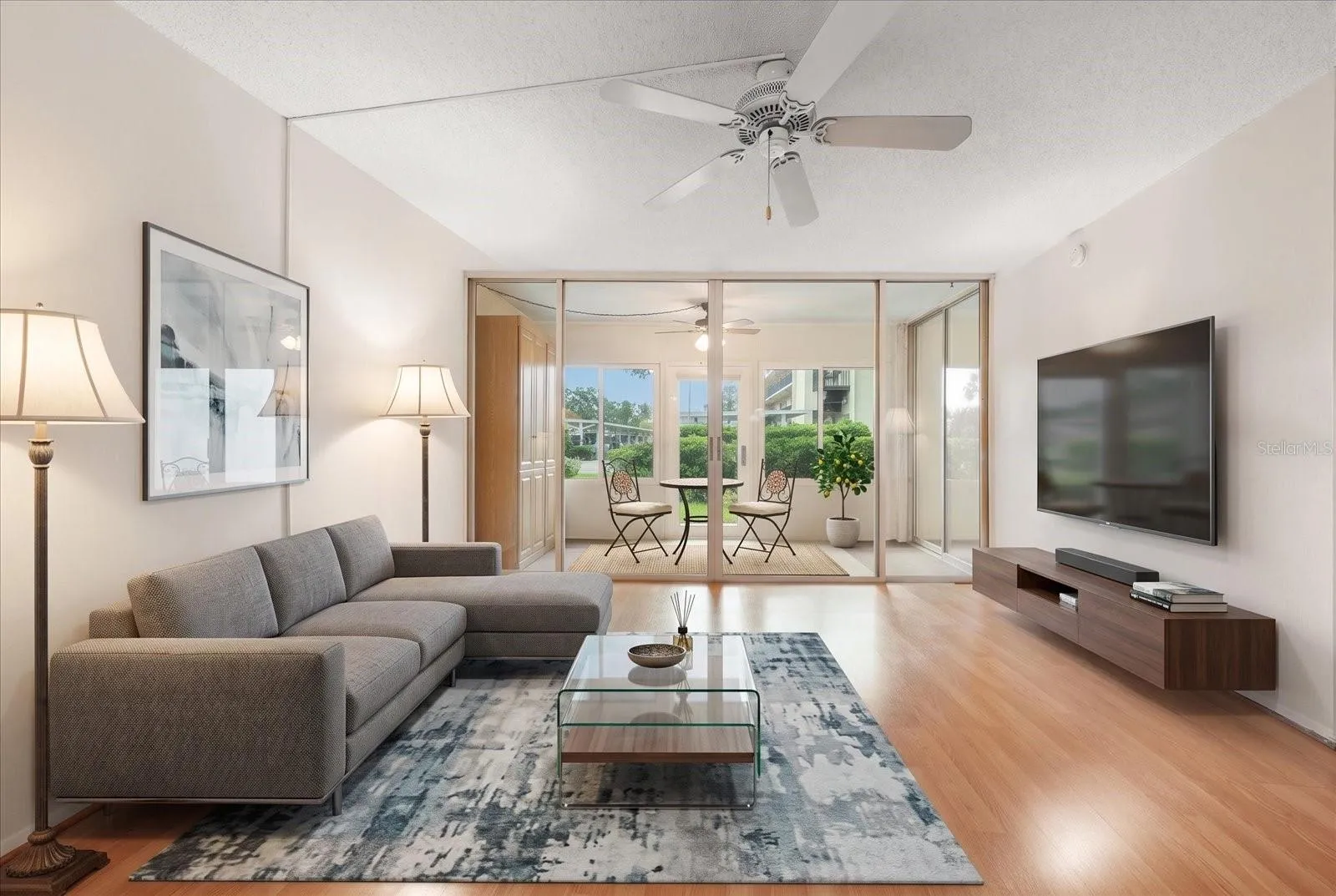 LIVING ROOM OVERLOOKS THE ENCLOSED FLORIDA ROOM WITH GARDEN VIEWS