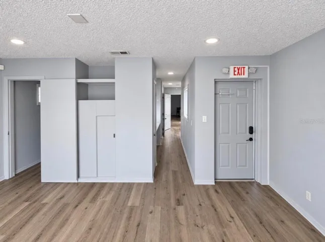 On the left are the entrance door to Office 1, a hallway leading to other offices, and the door to a half-bath.