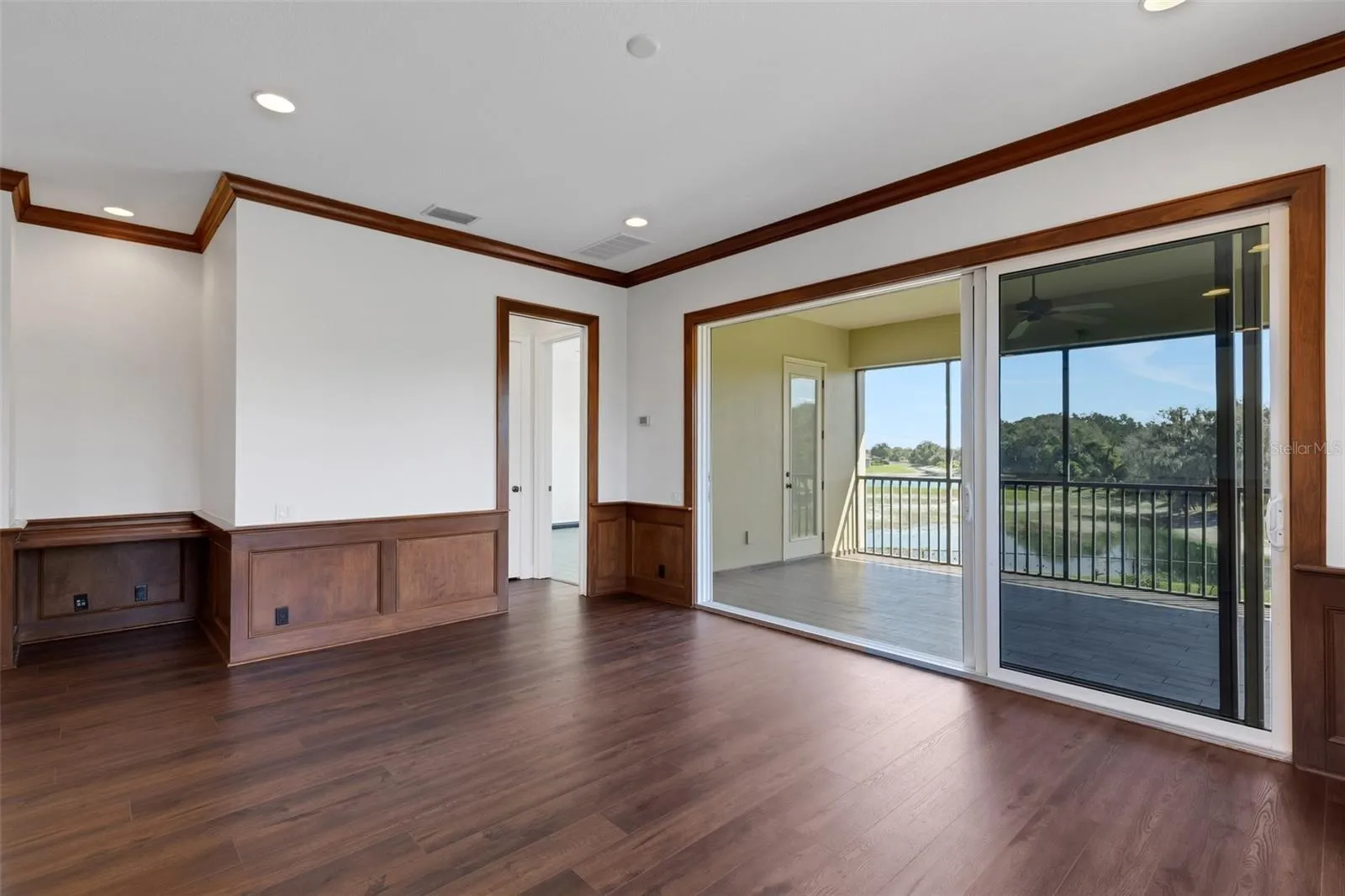 With a built-in desk, wood wainscoting accents, large stacking slider that opens to the screen enclosed balcony overlooking the pool area below.