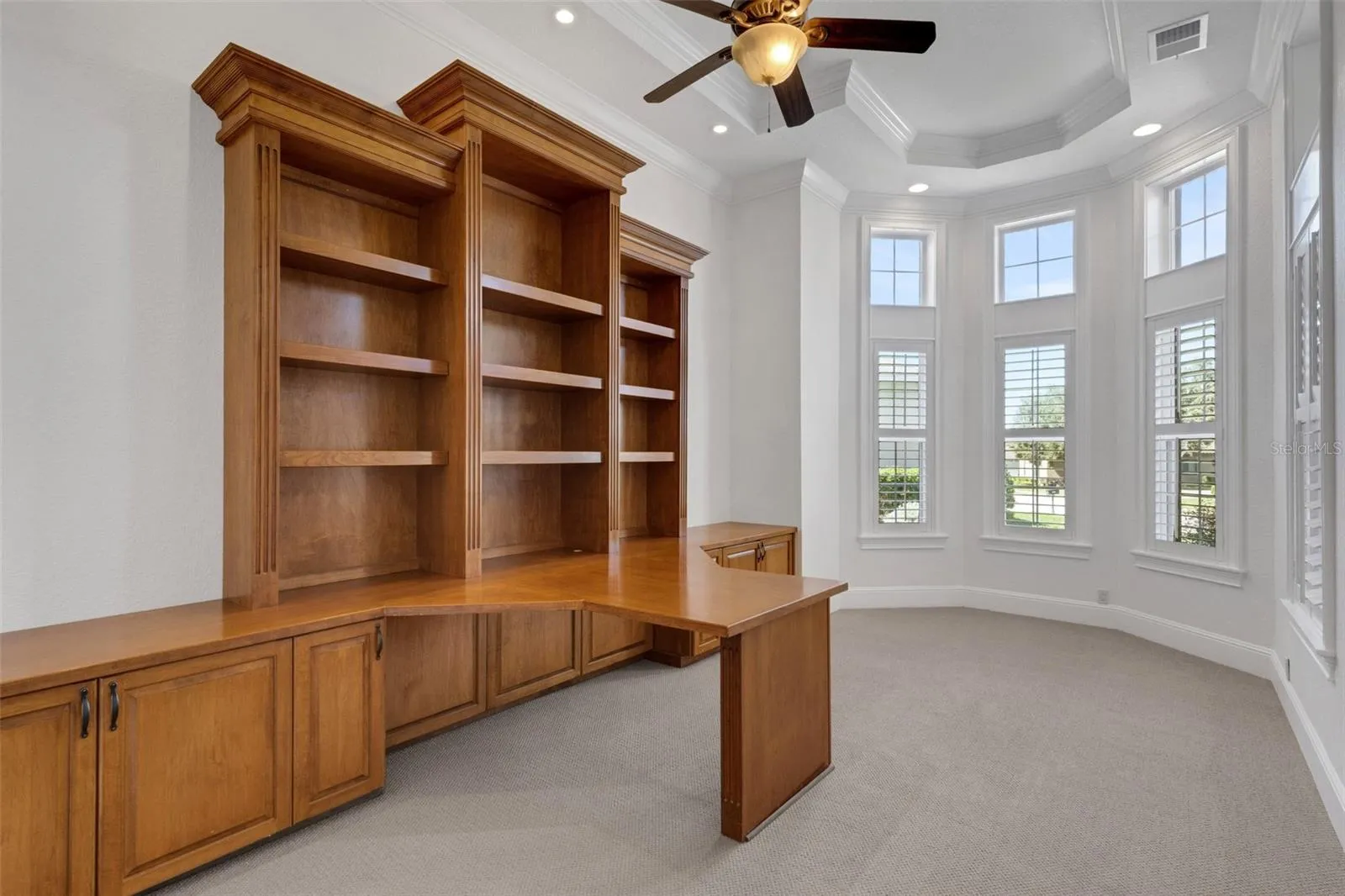 The office has a massive built-in two-person desk and shelf system.