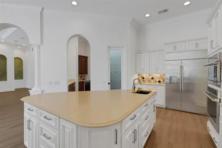 a large central island with an additional prep-sink, walk-in pantry and butler's pantry & bar alcove.