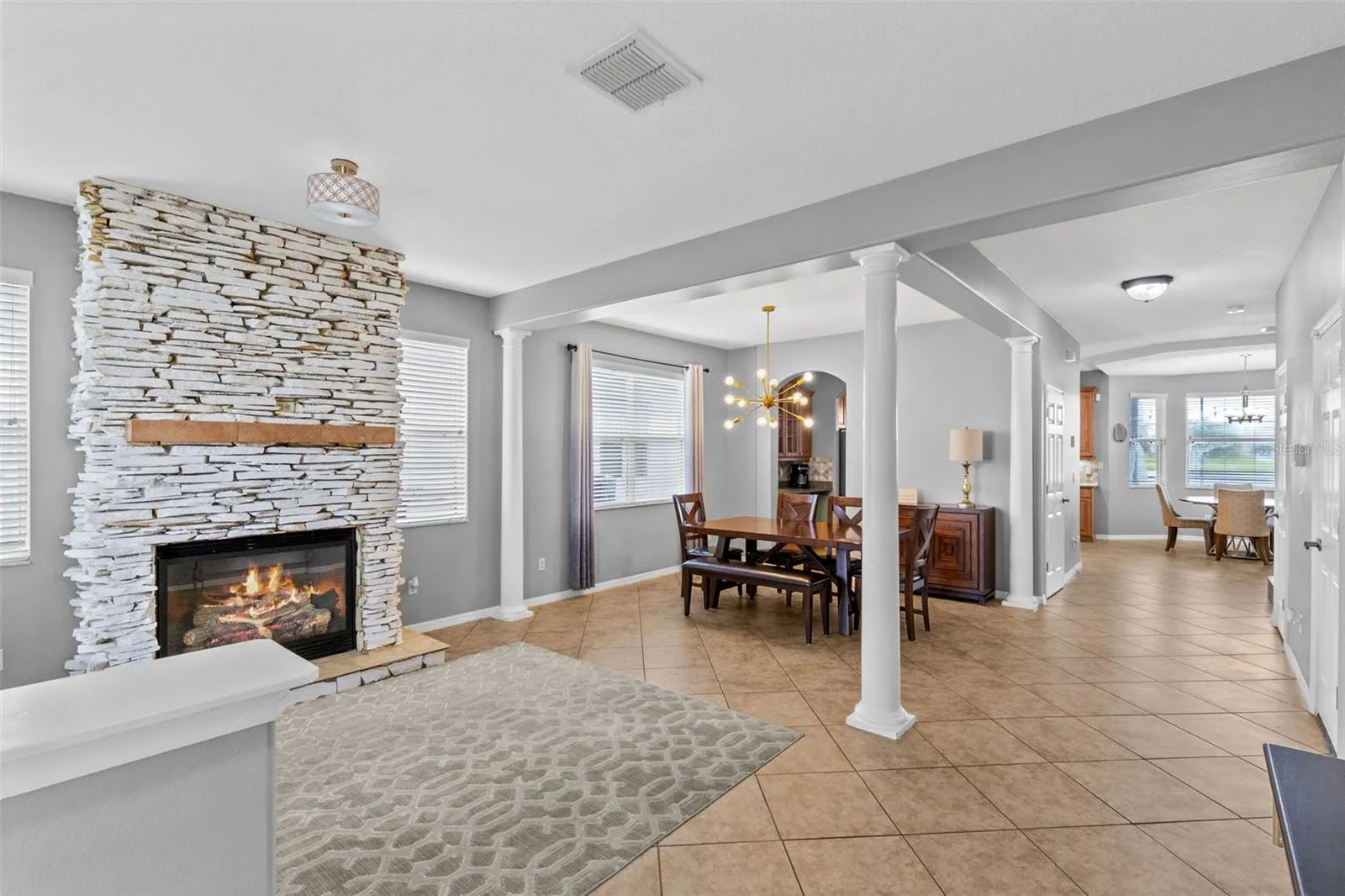A stone fireplace creates a warm focal point in the formal living room.