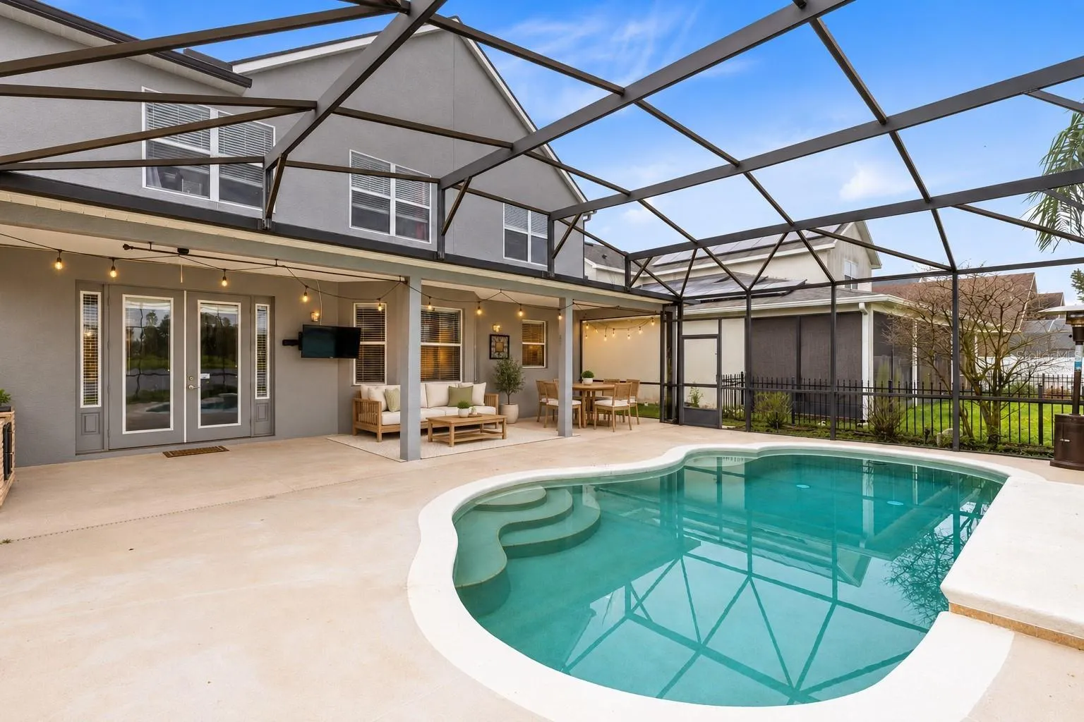Virtually Staged: Outside, the covered lanai and screened pool overlook the pond, creating a peaceful setting with no immediate rear neighbors. The outdoor space also includes a built in grill and partially fenced backyard.