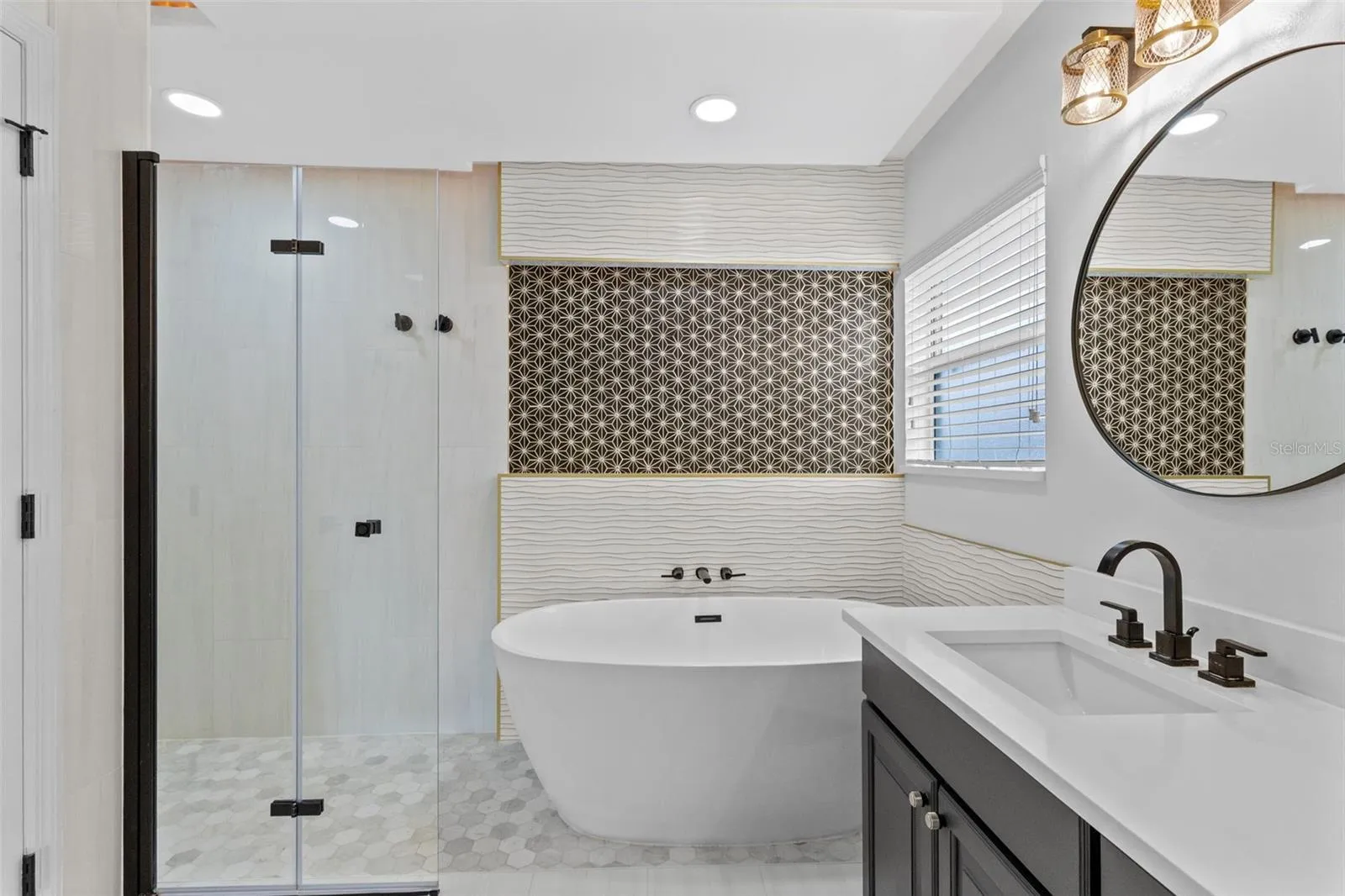 Completely gutted and rebuilt in 2022 with an investment of approximately $32,000, the primary bathroom includes a floating quartz double vanity, illuminated mirrors, an oversized walk in rain shower, multiple shower fixtures and lighted niches.