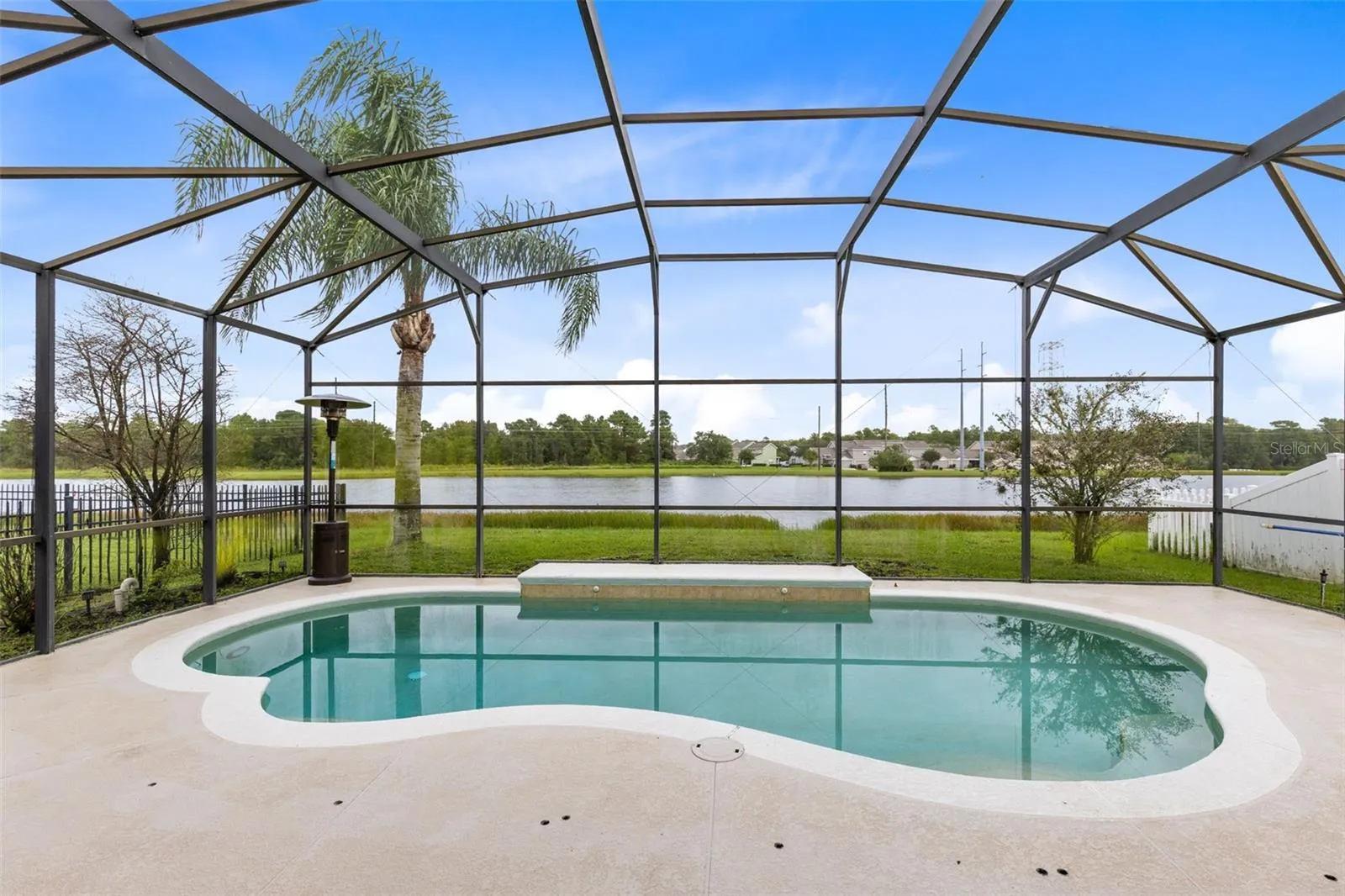 Outside, the covered lanai and screened pool overlook the pond, creating a peaceful setting with no immediate rear neighbors. The outdoor space also includes a built in grill and partially fenced backyard.