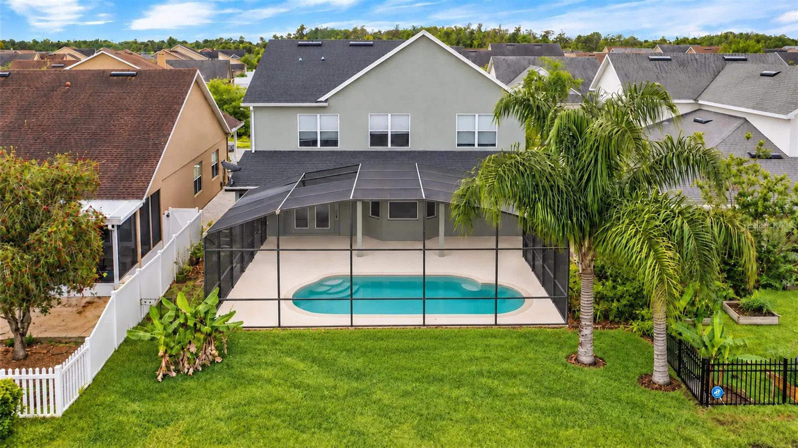 Outside, the covered lanai and screened pool overlook the pond, creating a peaceful setting with no immediate rear neighbors. The outdoor space also includes a built in grill and partially fenced backyard.