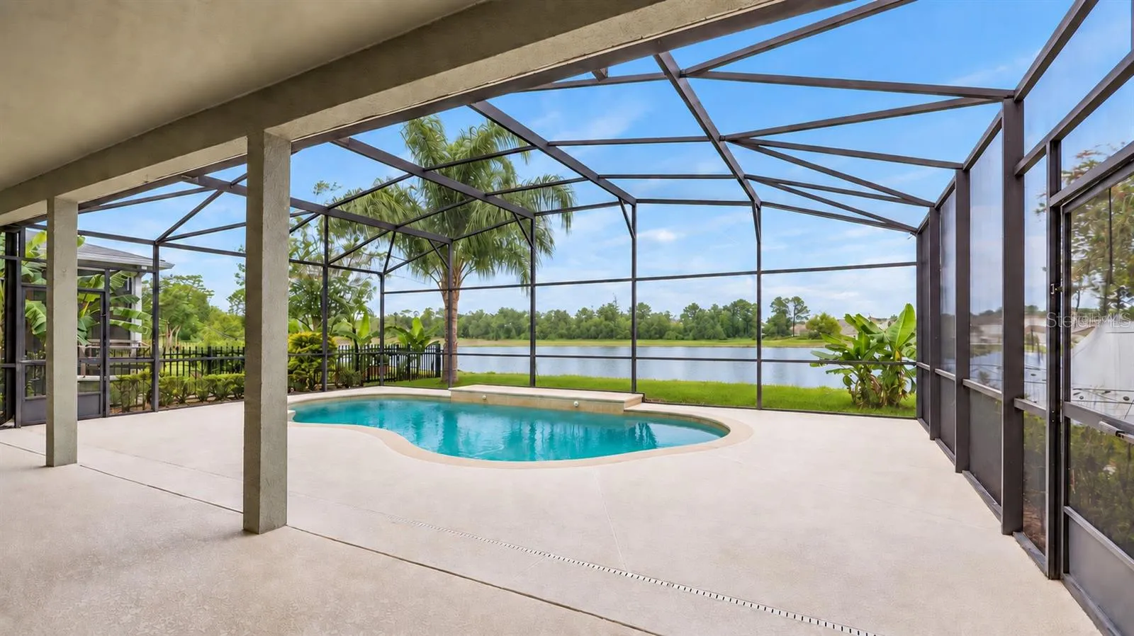 Outside, the covered lanai and screened pool overlook the pond, creating a peaceful setting with no immediate rear neighbors. The outdoor space also includes a built in grill and partially fenced backyard.