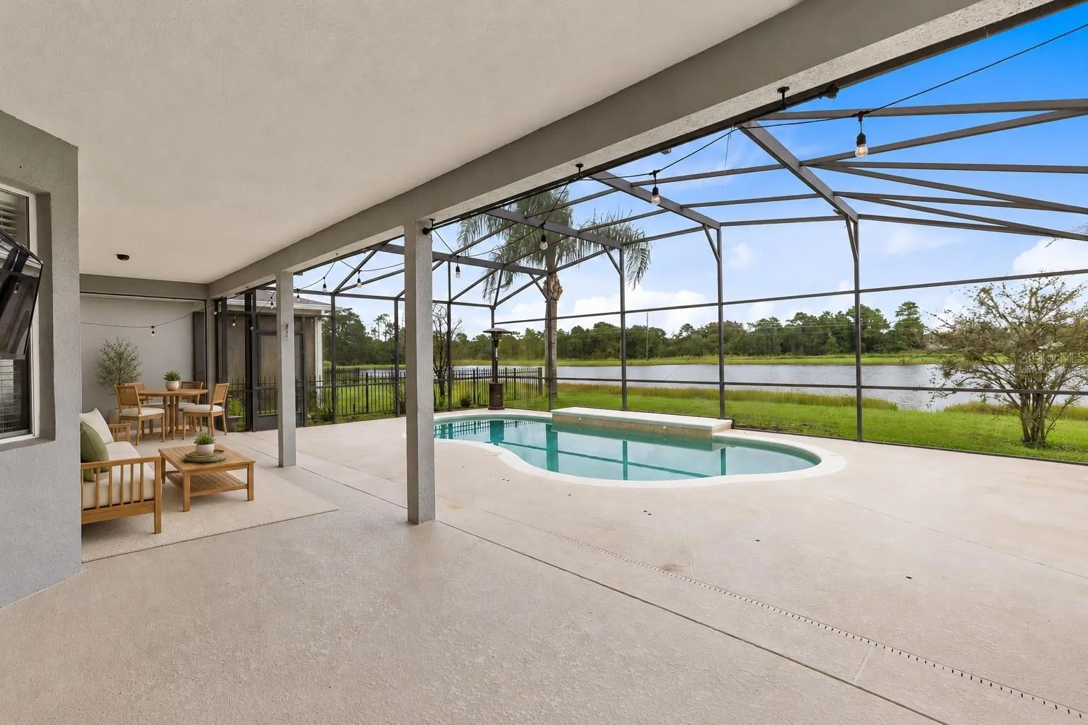 Virtually Staged: Outside, the covered lanai and screened pool overlook the pond, creating a peaceful setting with no immediate rear neighbors. The outdoor space also includes a built in grill and partially fenced backyard.