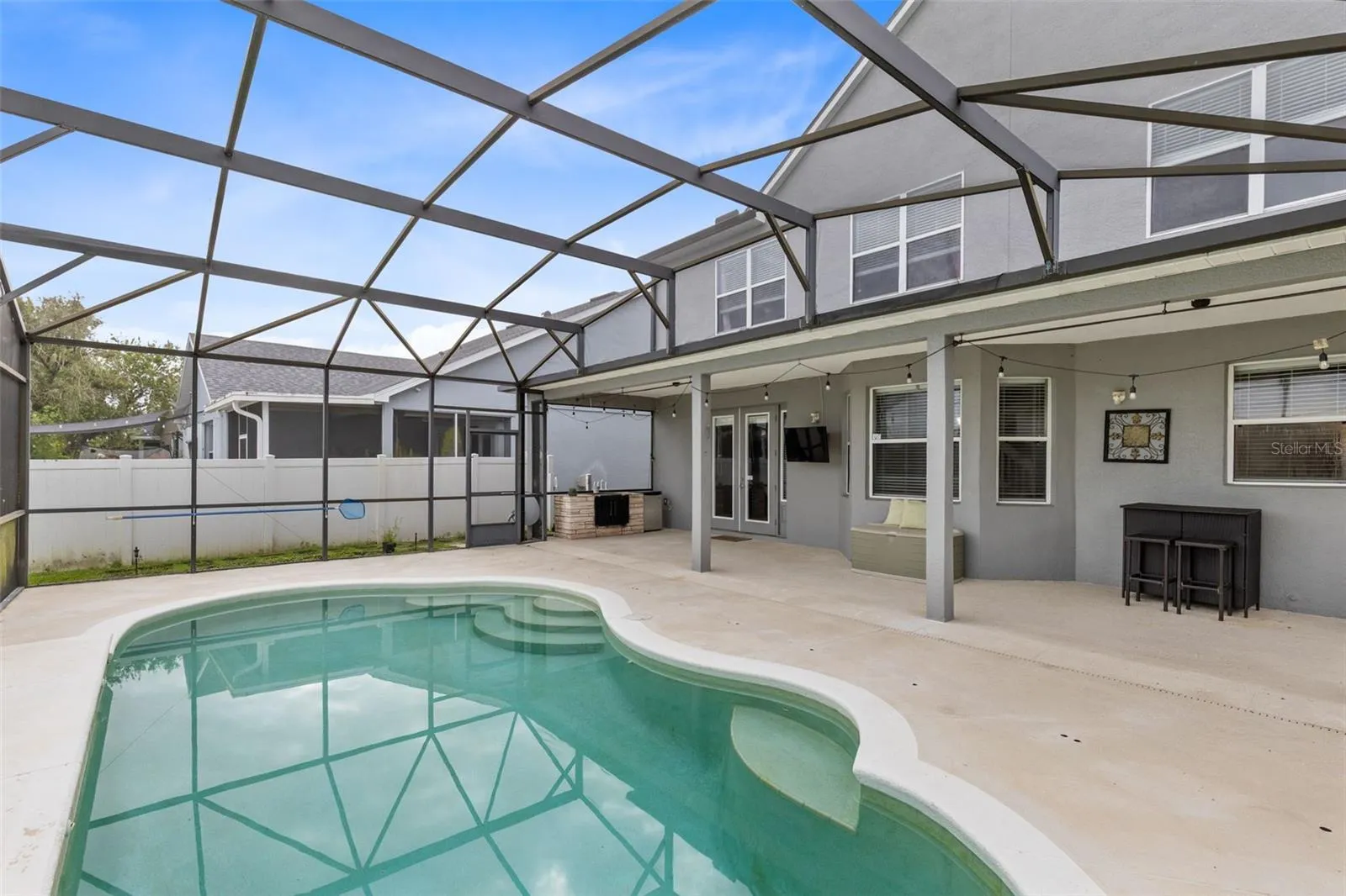 Outside, the covered lanai and screened pool overlook the pond, creating a peaceful setting with no immediate rear neighbors. The outdoor space also includes a built in grill and partially fenced backyard.