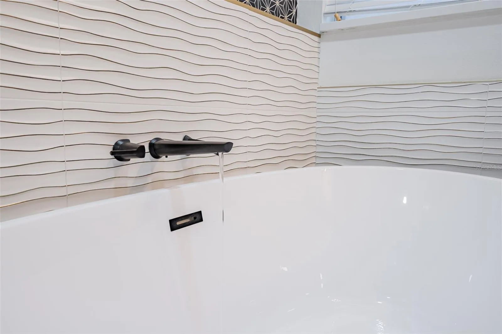 Completely gutted and rebuilt in 2022 with an investment of approximately $32,000, the primary bathroom includes a floating quartz double vanity, illuminated mirrors, an oversized walk in rain shower, multiple shower fixtures and lighted niches.
