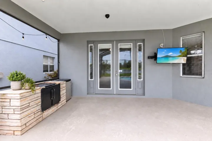 Outside, the covered lanai and screened pool overlook the pond, creating a peaceful setting with no immediate rear neighbors. The outdoor space also includes a built in grill and partially fenced backyard.