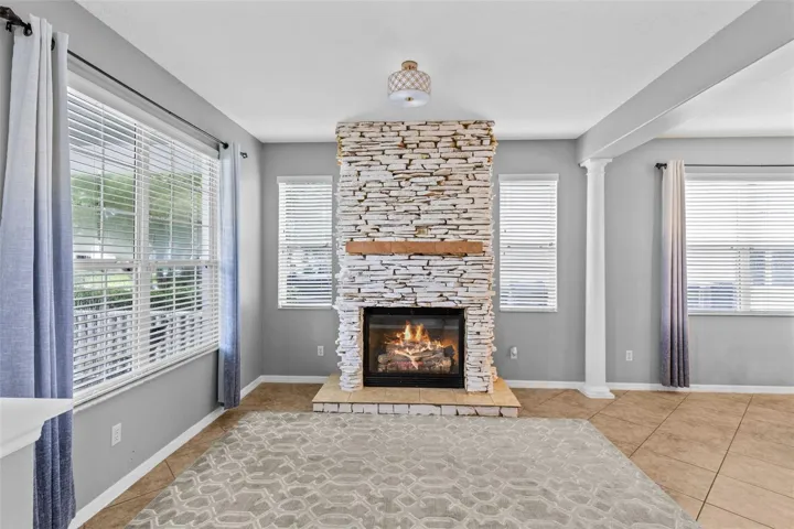 A stone fireplace creates a warm focal point in the formal living room.