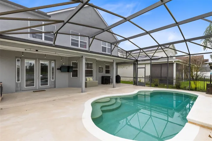 Outside, the covered lanai and screened pool overlook the pond, creating a peaceful setting with no immediate rear neighbors. The outdoor space also includes a built in grill and partially fenced backyard.