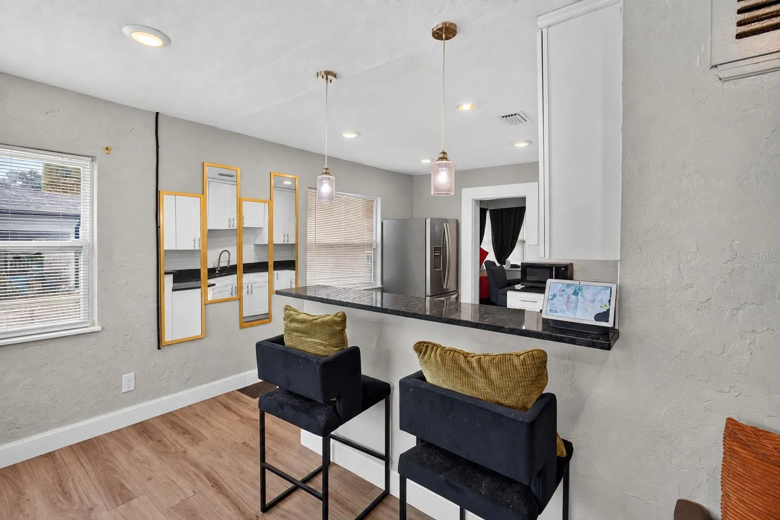 Virtually Staged. Personal Items digitally removed. Living room overlooking open kitchen with breakfast bar