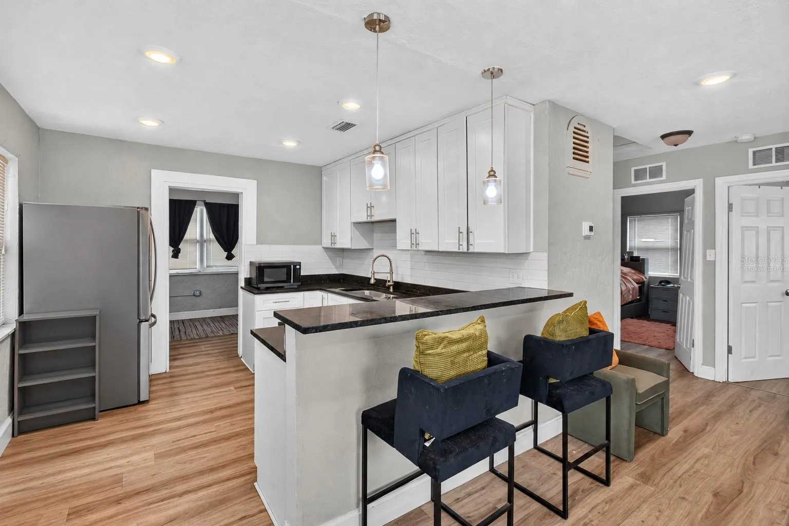 Virtually Staged. Personal Items digitally removed. Living room overlooking open kitchen with breakfast bar