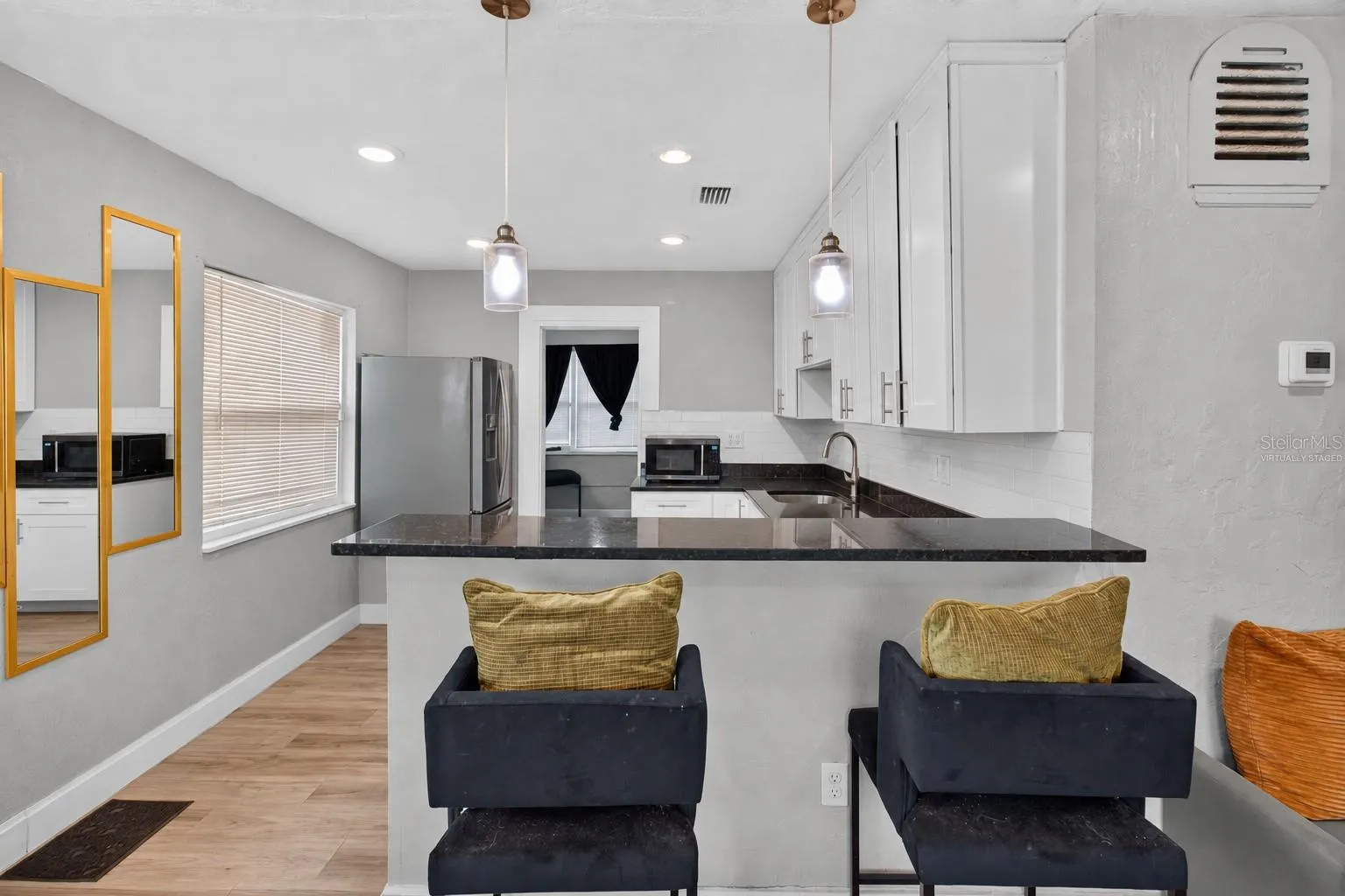 Virtually Staged. Personal Items digitally removed. Living room overlooking open kitchen with breakfast bar
