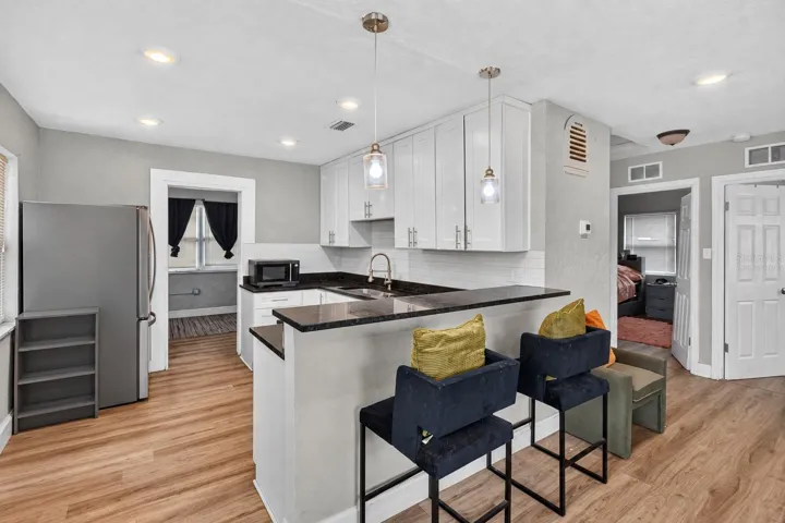 Virtually Staged. Personal Items digitally removed. Living room overlooking open kitchen with breakfast bar