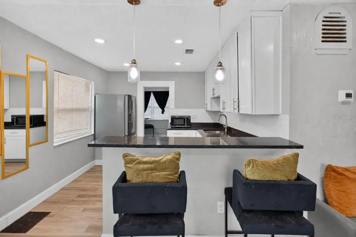 Virtually Staged. Personal Items digitally removed. Living room overlooking open kitchen with breakfast bar