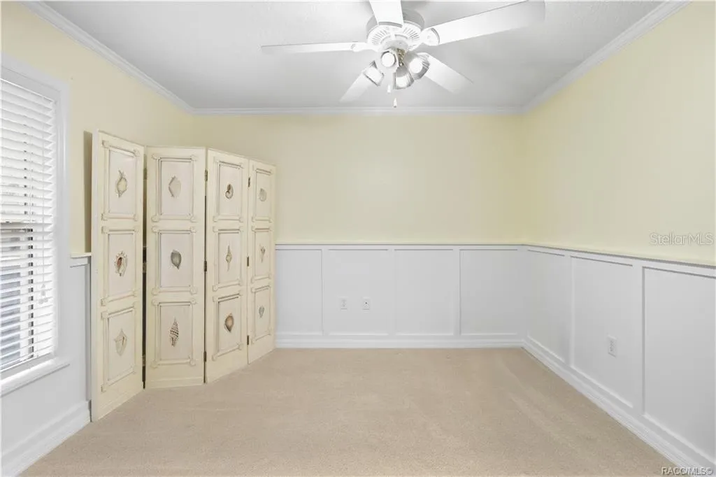 Additional Guest Bedroom – Alternate view highlighting the room’s size, natural light and decorative wall detail/wainscoating.