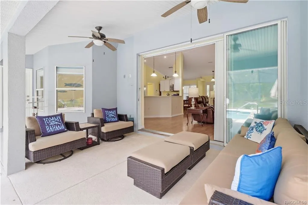 Covered Lanai – Alternate view showing the spacious seating area, dual ceiling fans and pocket sliding-door connection to the interior.