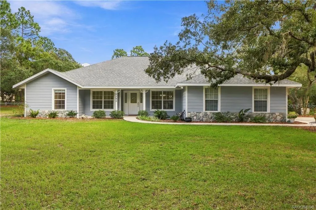 Front Exterior – BRAND NEW ROOF 2026 – Full front elevation highlighting the expansive lawn, covered entry porch, mature shade trees. FRESHLY painted exterior trim.