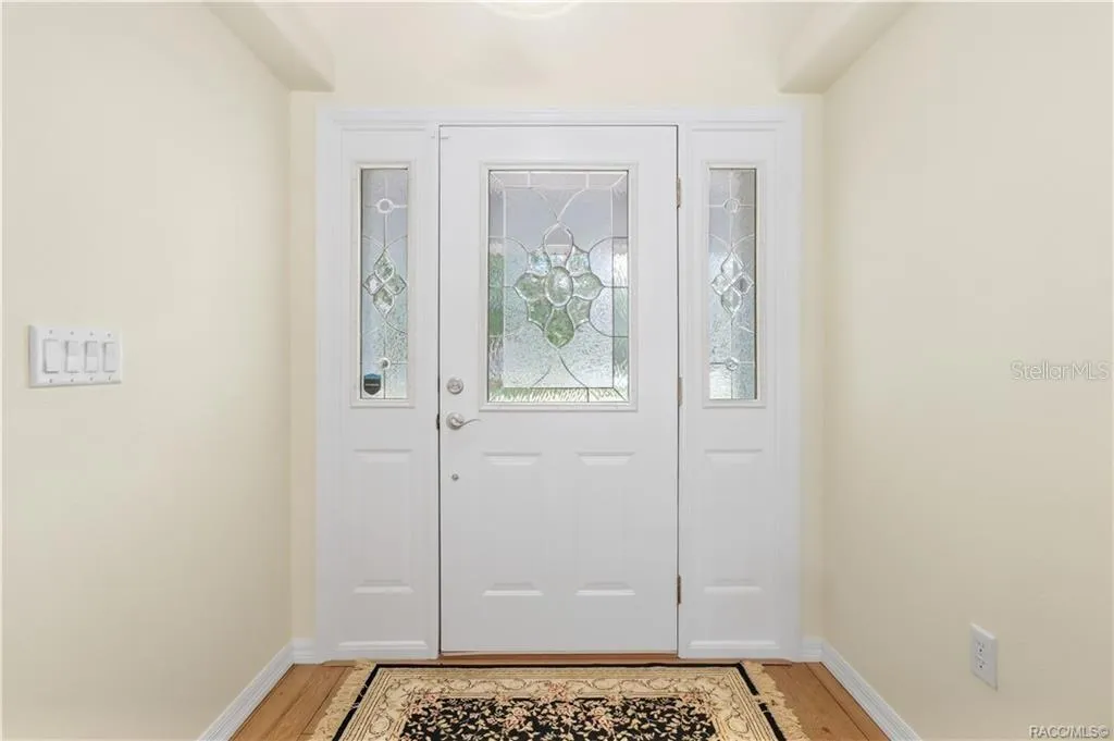 Foyer – Bright entry featuring decorative glass front door with matching sidelights and laminate flooring.