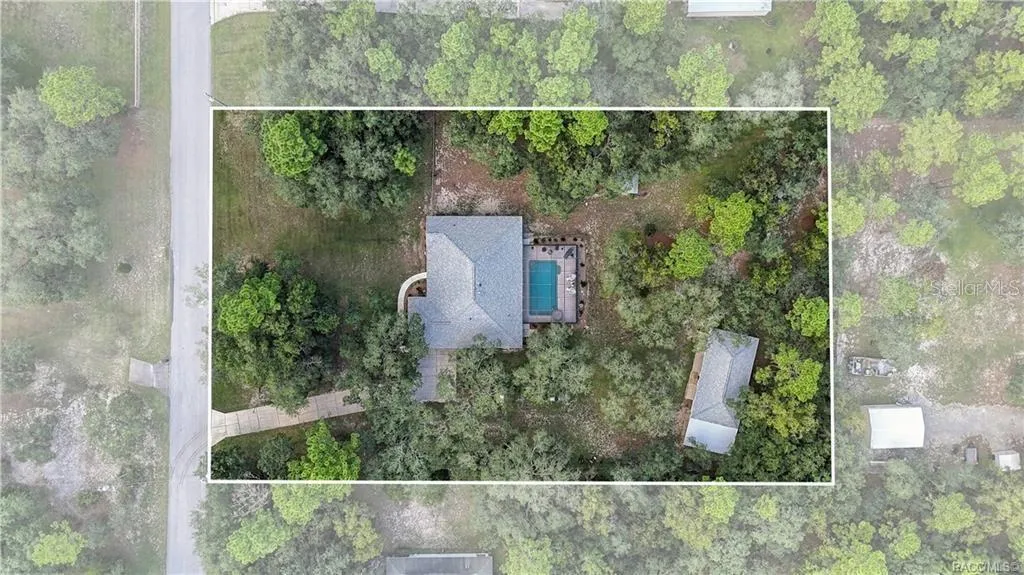 Aerial View – Overhead view showcasing the spacious homesite, residence, screened pool area, detached garage/outbuilding, mature trees &amp; surrounding property.