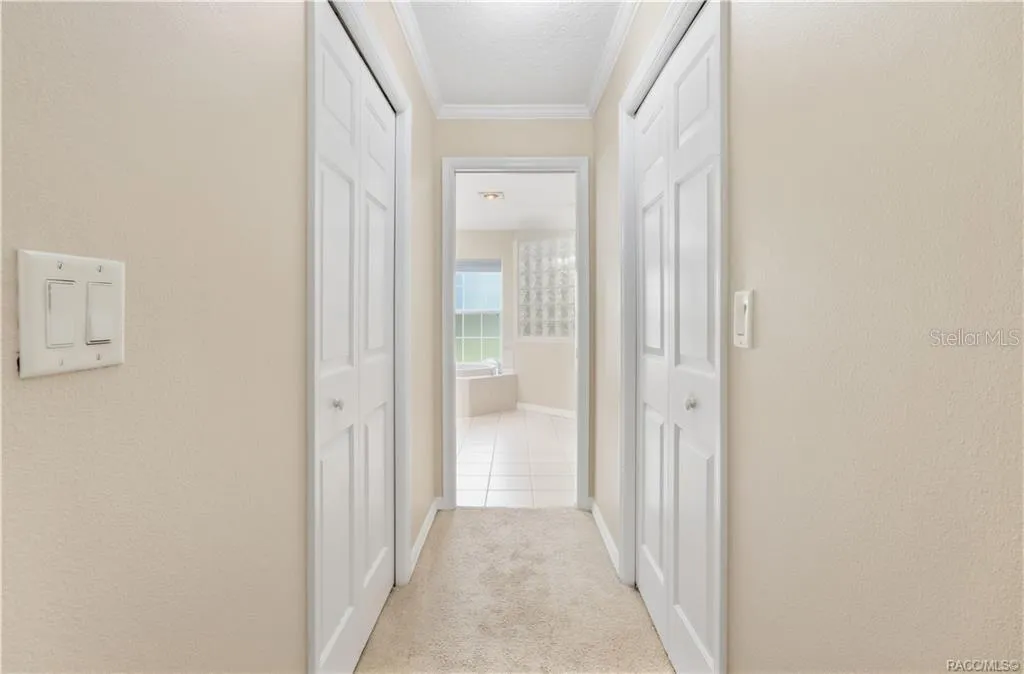Primary Suite Hallway – Hallway leading from the primary bedroom to the ensuite bath, with closets on both sides for added storage.