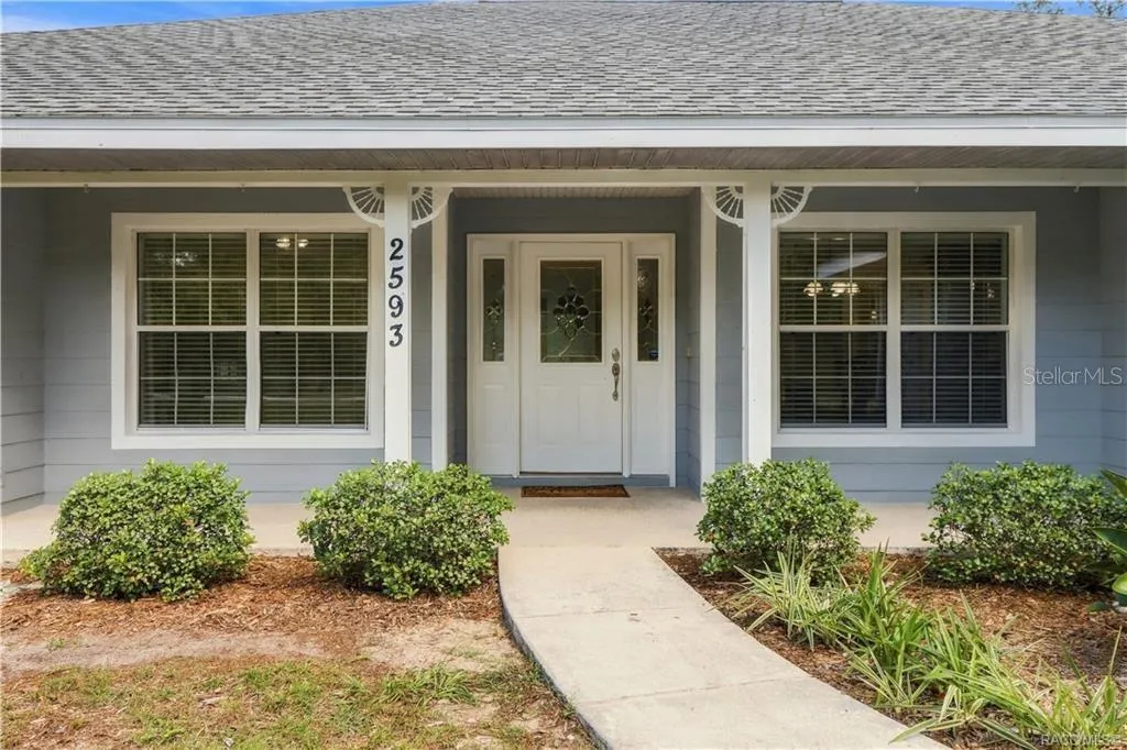Covered Front Entry – Welcoming covered front porch with landscaped walkway, decorative glass front door &amp; sidelights.