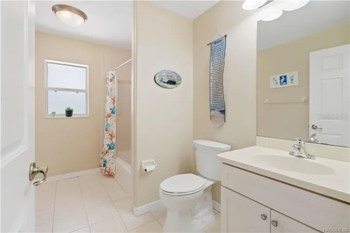 Guest Bathroom – Full guest bath with vanity, tub/shower combination, tile flooring and window for natural light.
