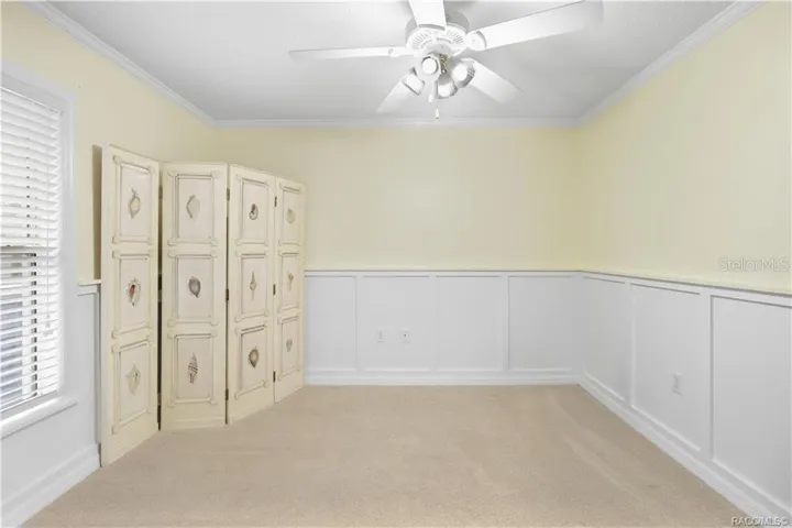 Additional Guest Bedroom – Alternate view highlighting the room’s size, natural light and decorative wall detail/wainscoating.