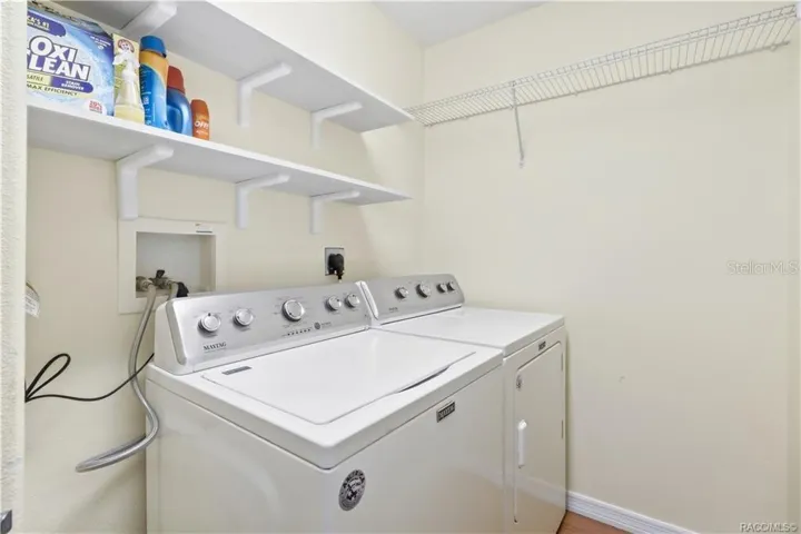 Indoor Laundry Room – Dedicated laundry area with washer and dryer, shelving and additional storage space.