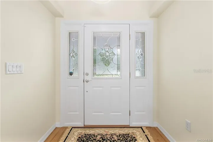 Foyer – Bright entry featuring decorative glass front door with matching sidelights and laminate flooring.