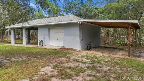 MORE ROOM FOR THE TOYS – Rear view of the detached garage with extended covered parking/storage area.