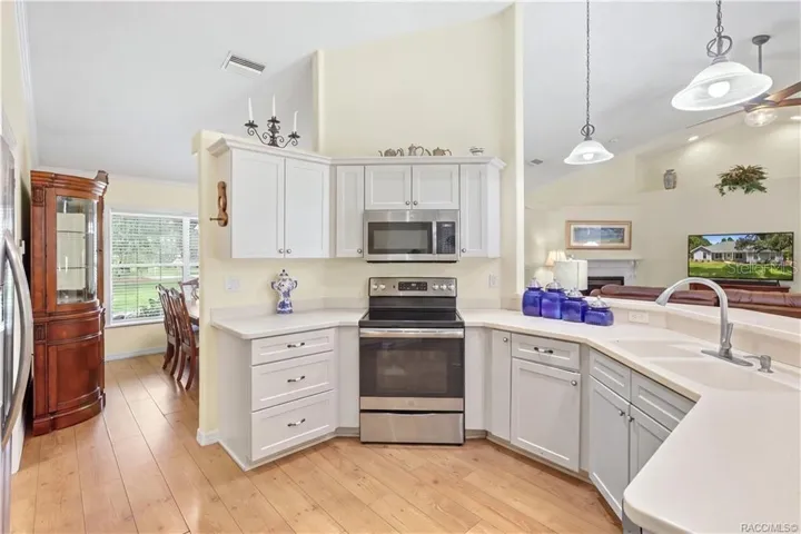 Kitchen / Open Floor Plan – Additional kitchen view showcasing the cabinetry, stainless-steel appliances, breakfast bar &amp; open connection to the living area.