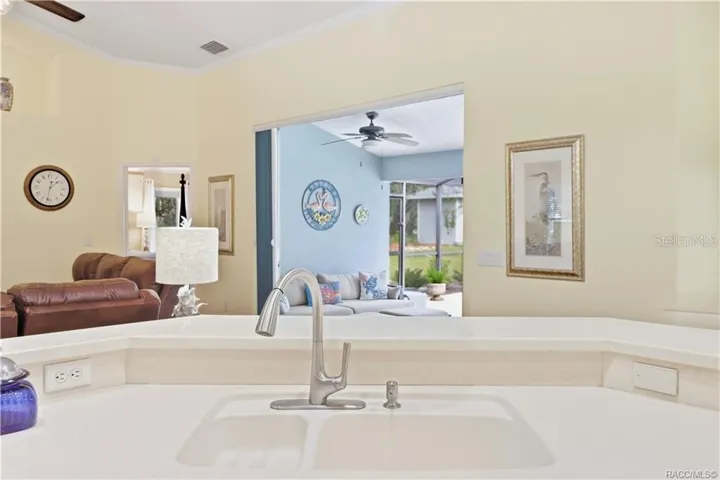 Kitchen Breakfast Bar – Generous counter space with raised breakfast bar, sink &amp; open sightlines into the living room and screened pool lanai.