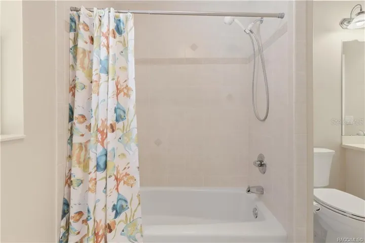 Guest Bathroom – Closer view of the tiled tub/shower combination with handheld showerhead.