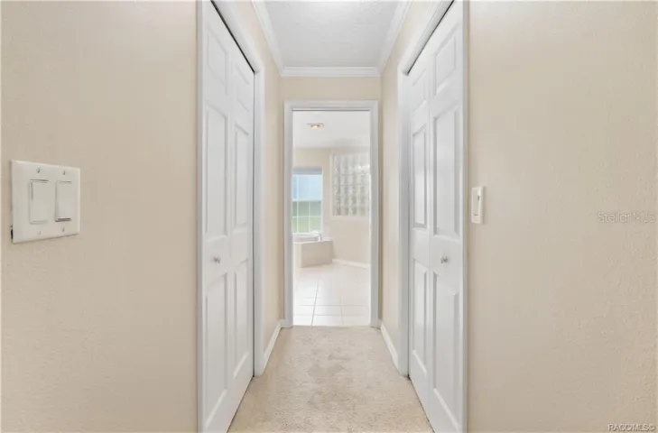 Primary Suite Hallway – Hallway leading from the primary bedroom to the ensuite bath, with closets on both sides for added storage.